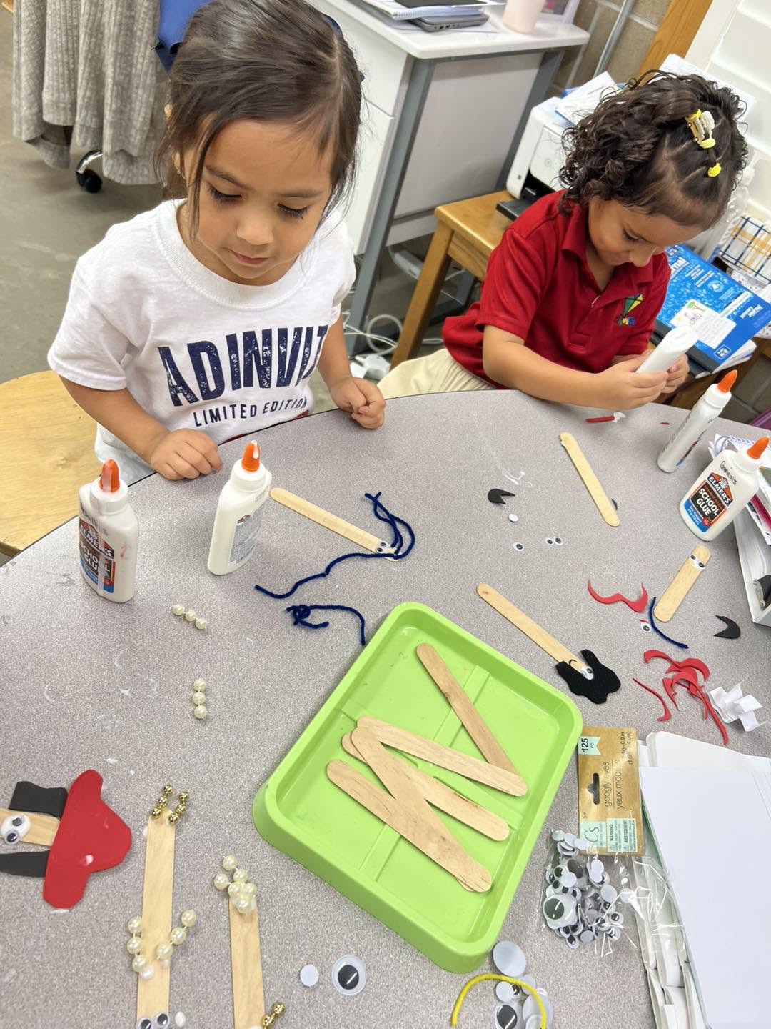 Two Adinvita students creating craft projects side by side